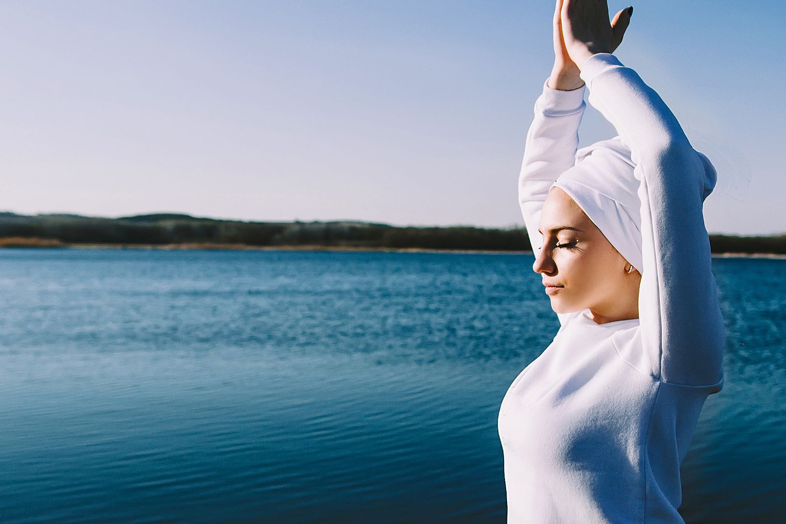 Frau praktiziert Kundalini Yoga im Freien