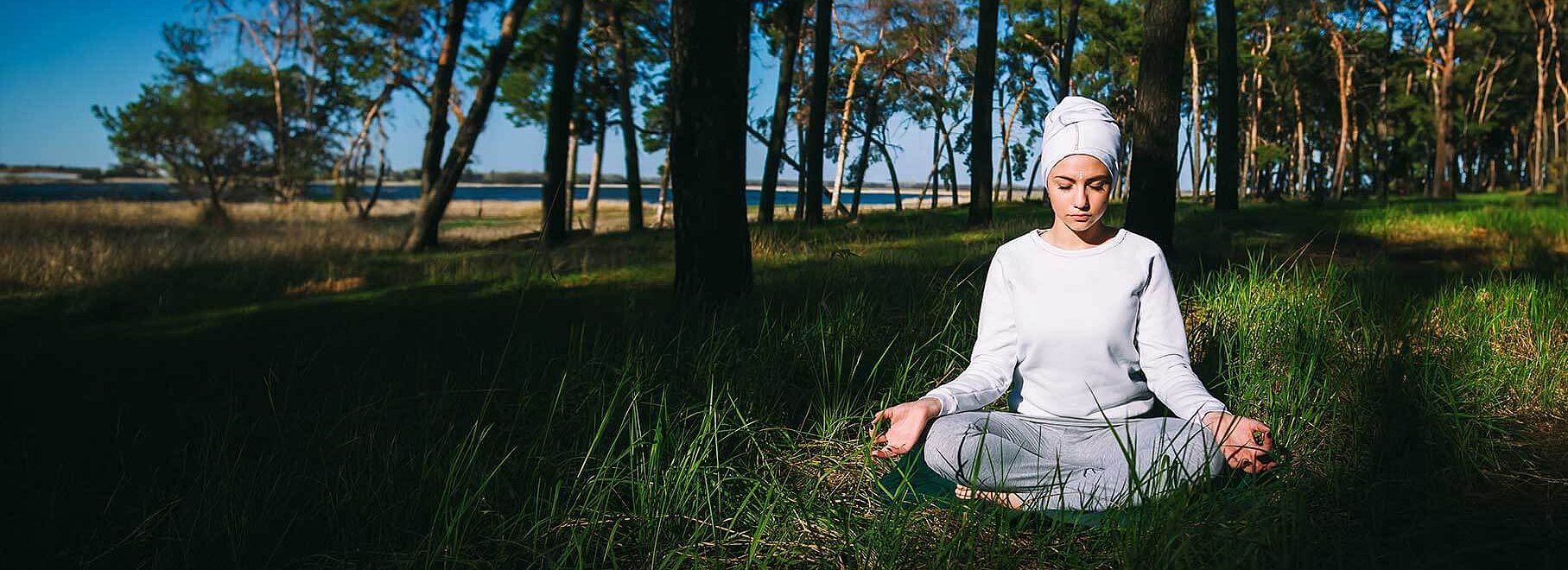 Frau mit weißem Turban bei einer Kundalini Yoga-Übung