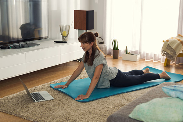 Frau übt yoga zuhause mit Labtop