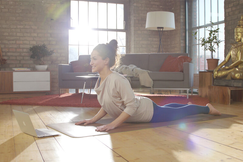 Frau praktiziert Sivananda Yoga per Online Yoga